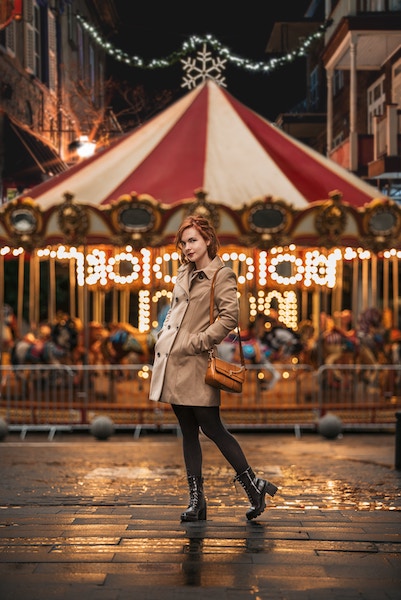 A girl posing in front of a carousel in the christmas markets in Madrid