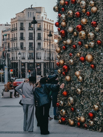 Two girls taking a picture at the Christmas lights of Hermes in Gran Via Madrid