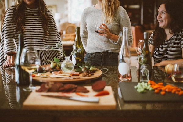 three women having tapas with drinks, laughing