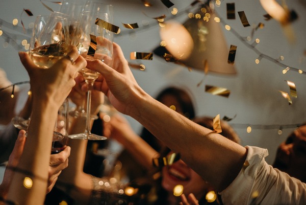 Celebrating the New Year's Eve with champagne under golden confetti