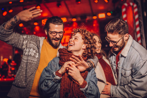 Group of friends at outdoor winter party, music concert, dancing