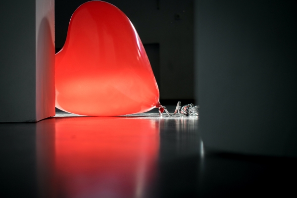 A red heart-shaped balloon on top of the floor.