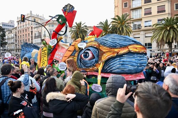 Sardine burning parade during the carnival in Malaga - city street with a crowd of carnival participants