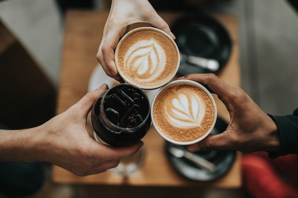 friends cheering two lattes and one cold brew best coffee in Barcelona