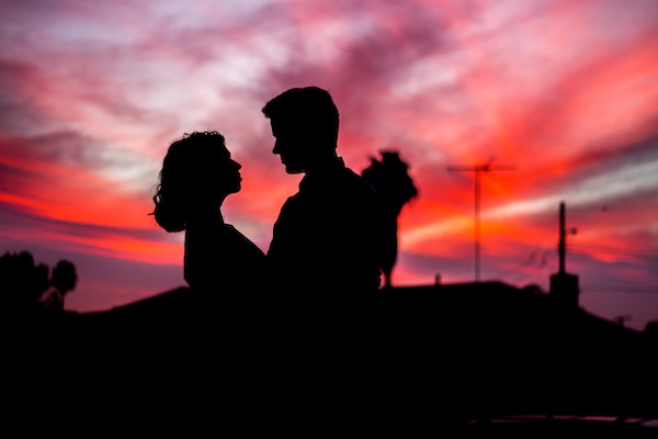 Couple in Sunseti pink background, human siluettes