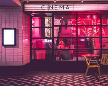 Several people climbing up the stairs to attend a film festival inside a movie theater.