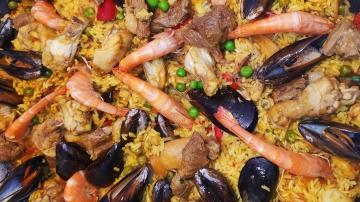 A plate with mixed toppings of seafood and meat.