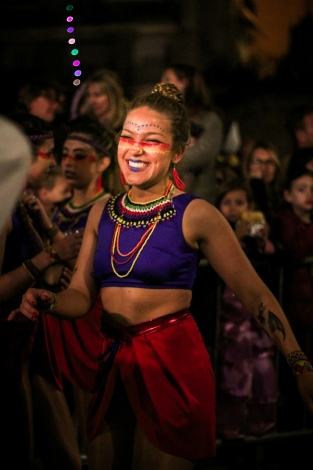 A woman in purple crop top performing in Sitges in an event similar to Carnival in Cadiz 2024, Spain.