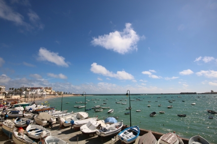 Docked boats during the day in Playa de Caleta in Cadiz, Spain.