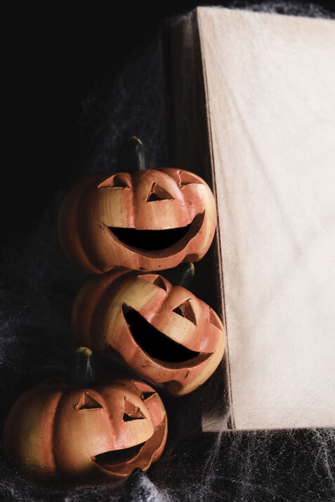 Stack of carved Halloween pumpkins with smiling faces.